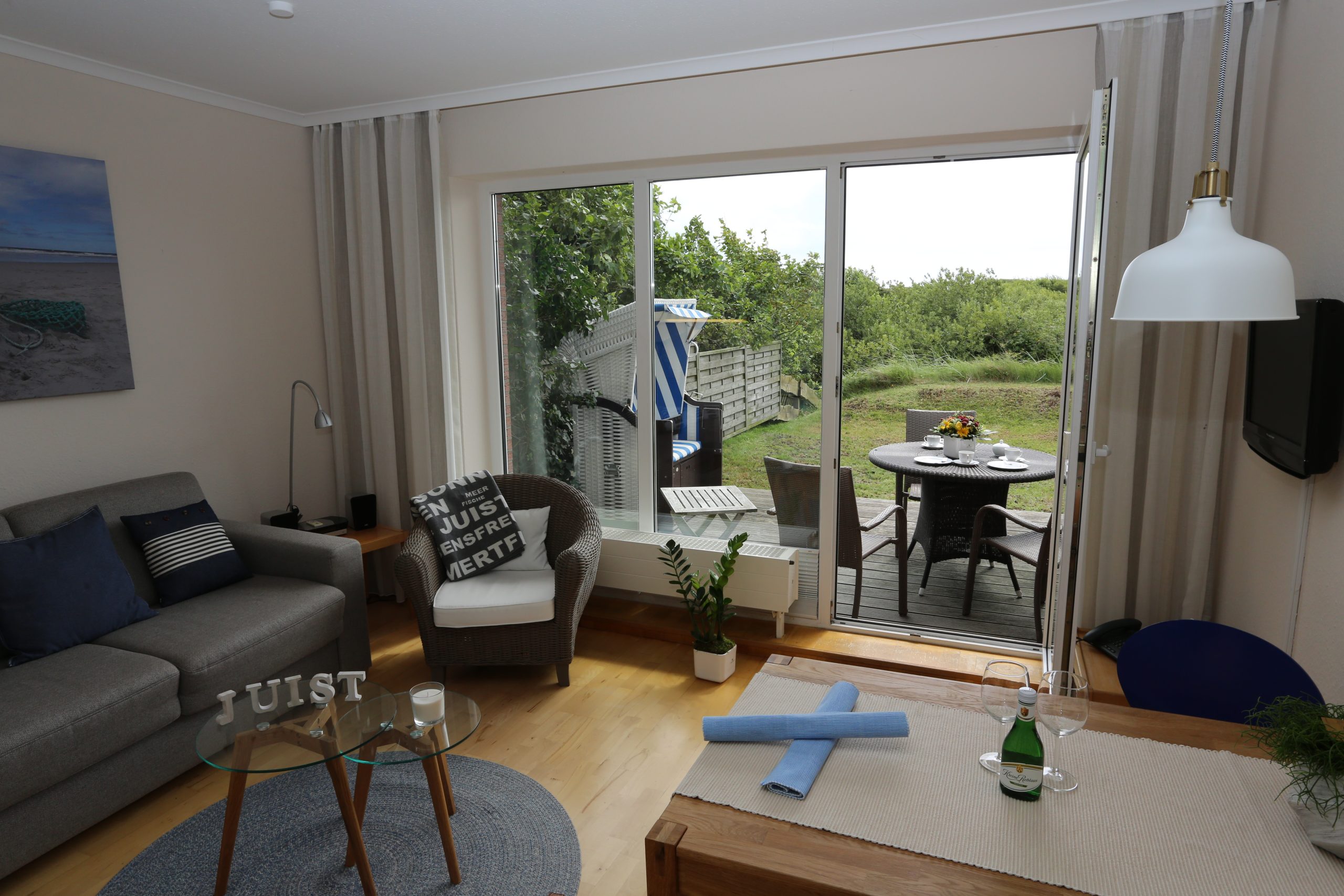 Wohnbereich der Ferienwohnung Backbord mit Terrasse und Strandkorb
