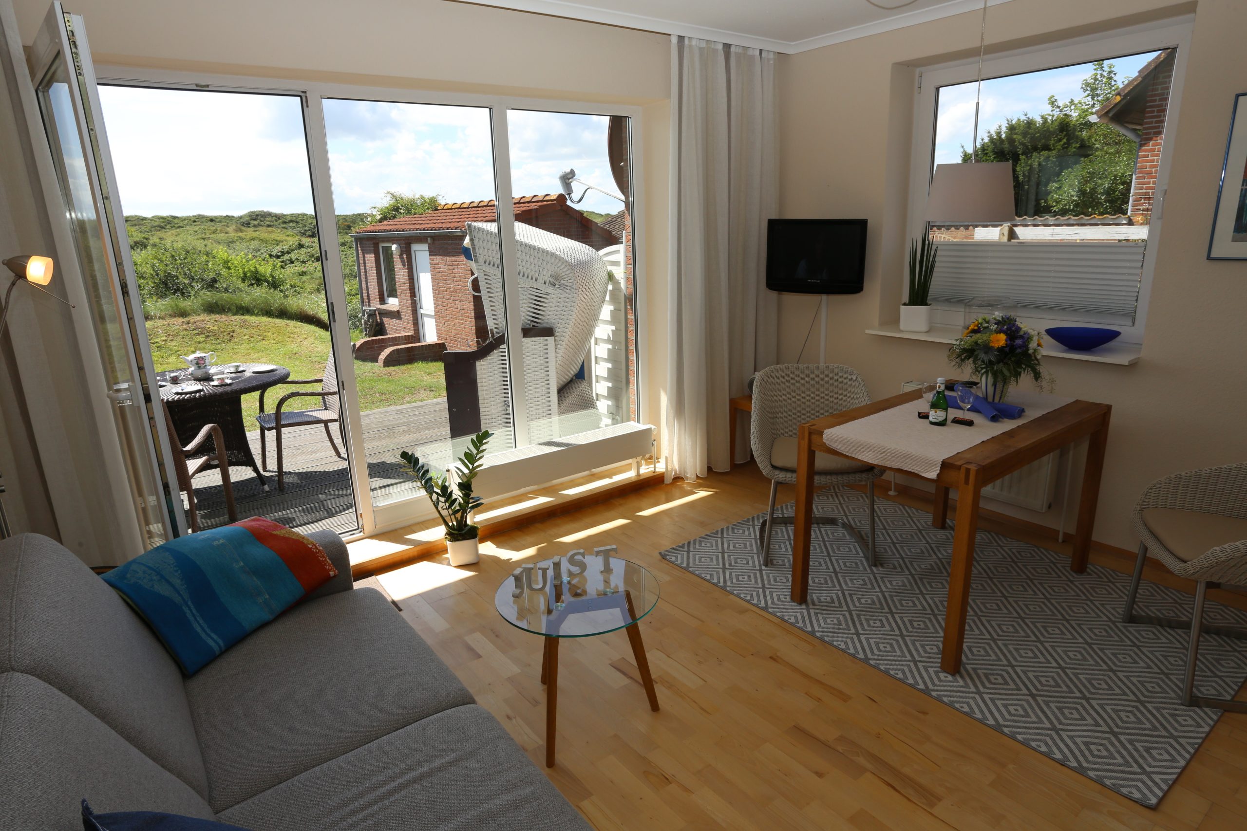 Wohnbereich der Ferienwohnung Steuerbord mit Terrasse und Blick ins Grüne