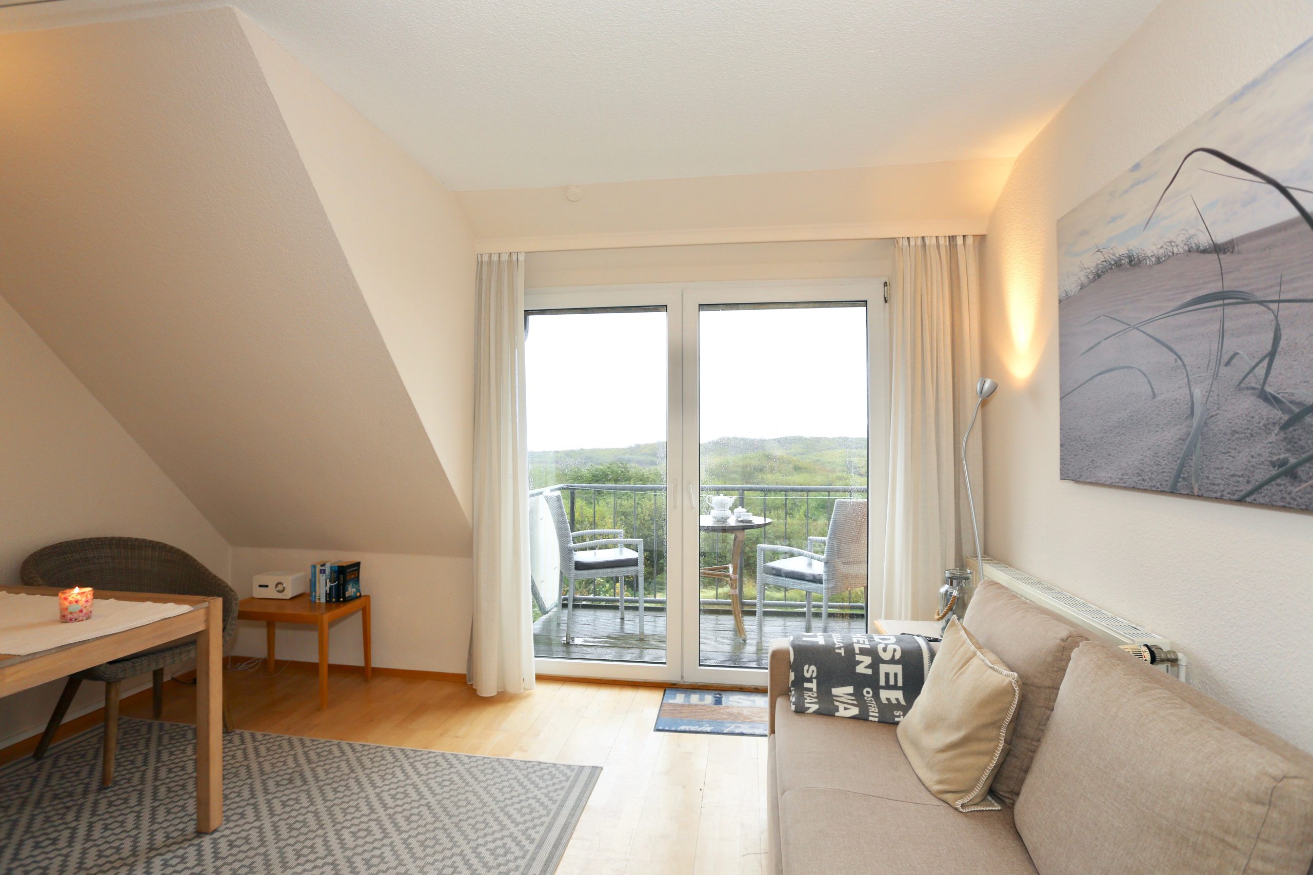 Wohnbereich der Ferienwohnung Ausguck mit Balkon und weitem Blick über die Dünen